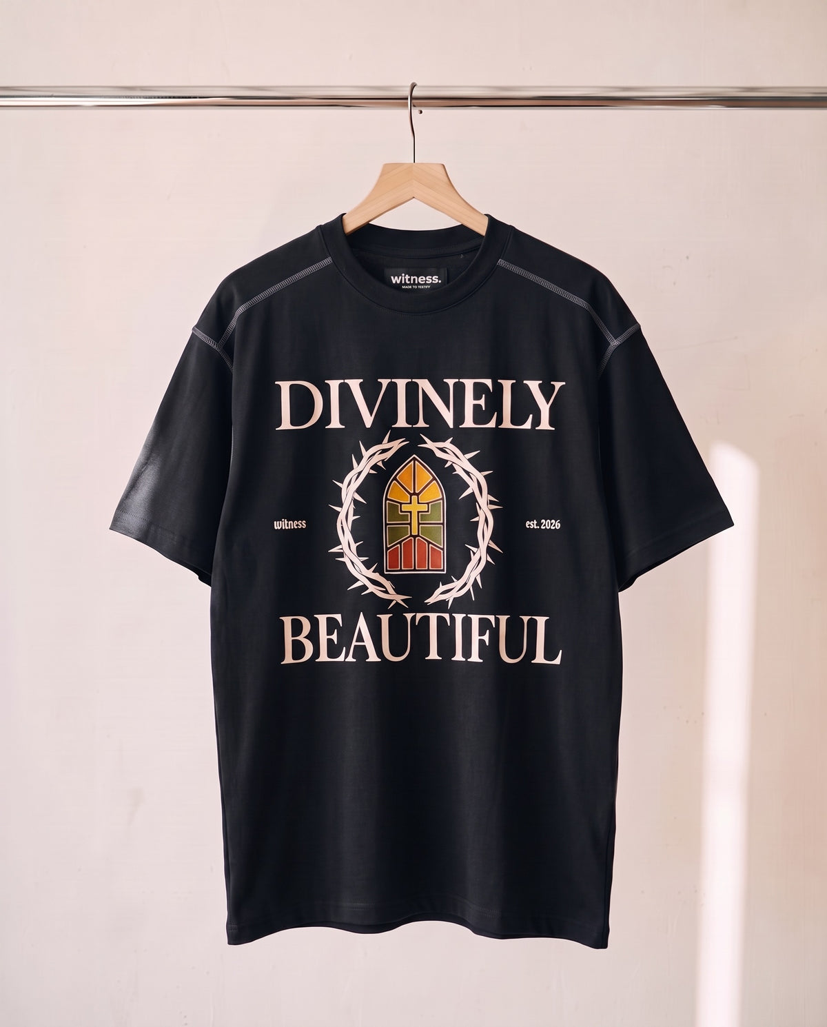 Divinely Beautiful tee in black on a wood hanger