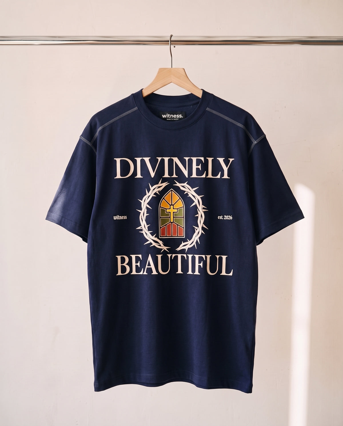 Divinely Beautiful tee in navy on a wood hanger