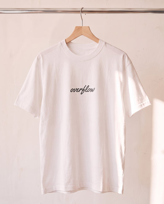 Overflow Christian tee in white on a wood hanger, front