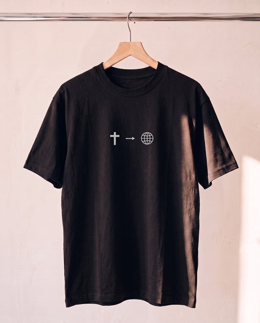Tell The World Christian tee in black on a wood hanger, front